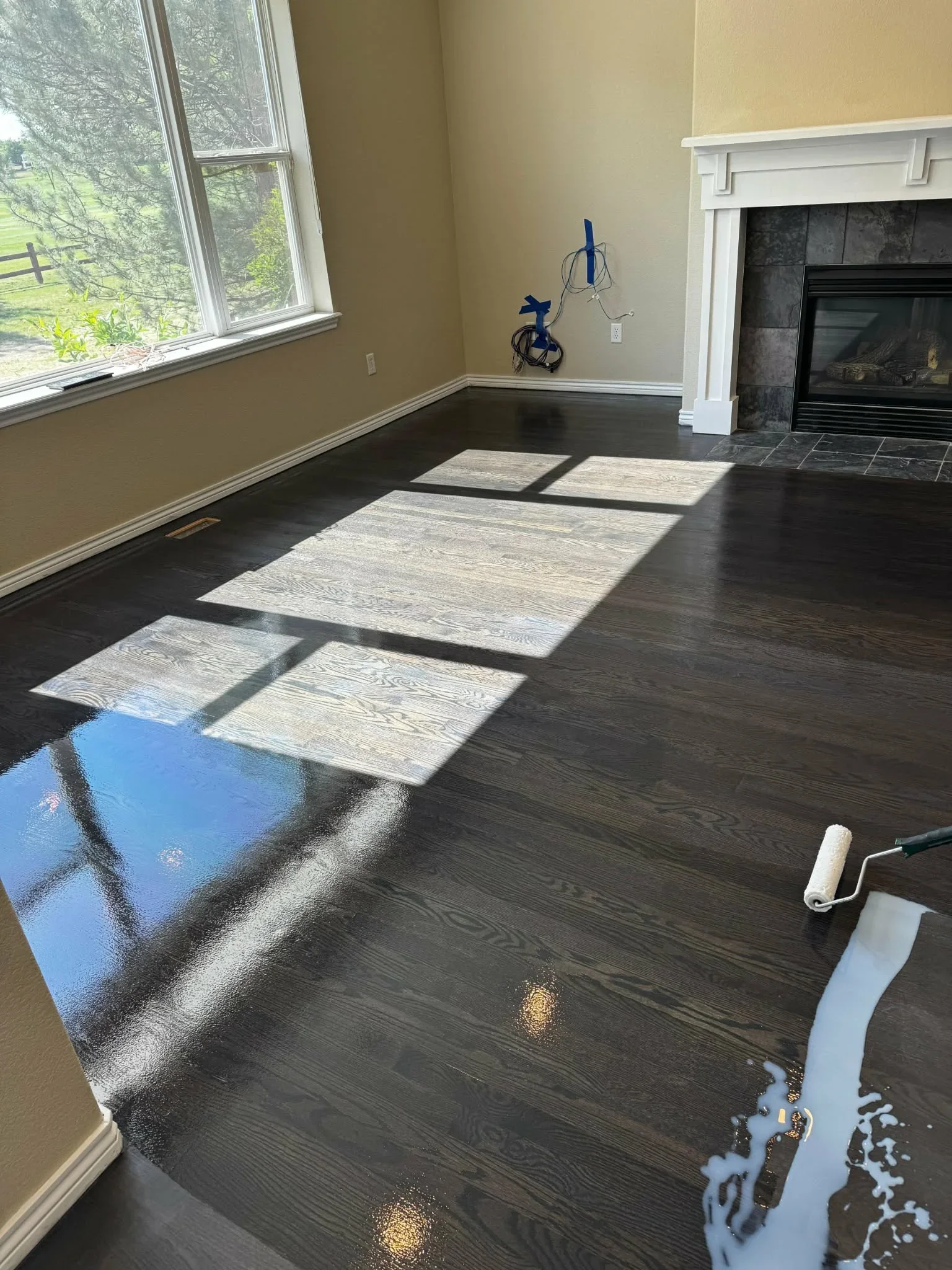Dark hardwood flooring installation in progress with sample tiles and protective coverings
