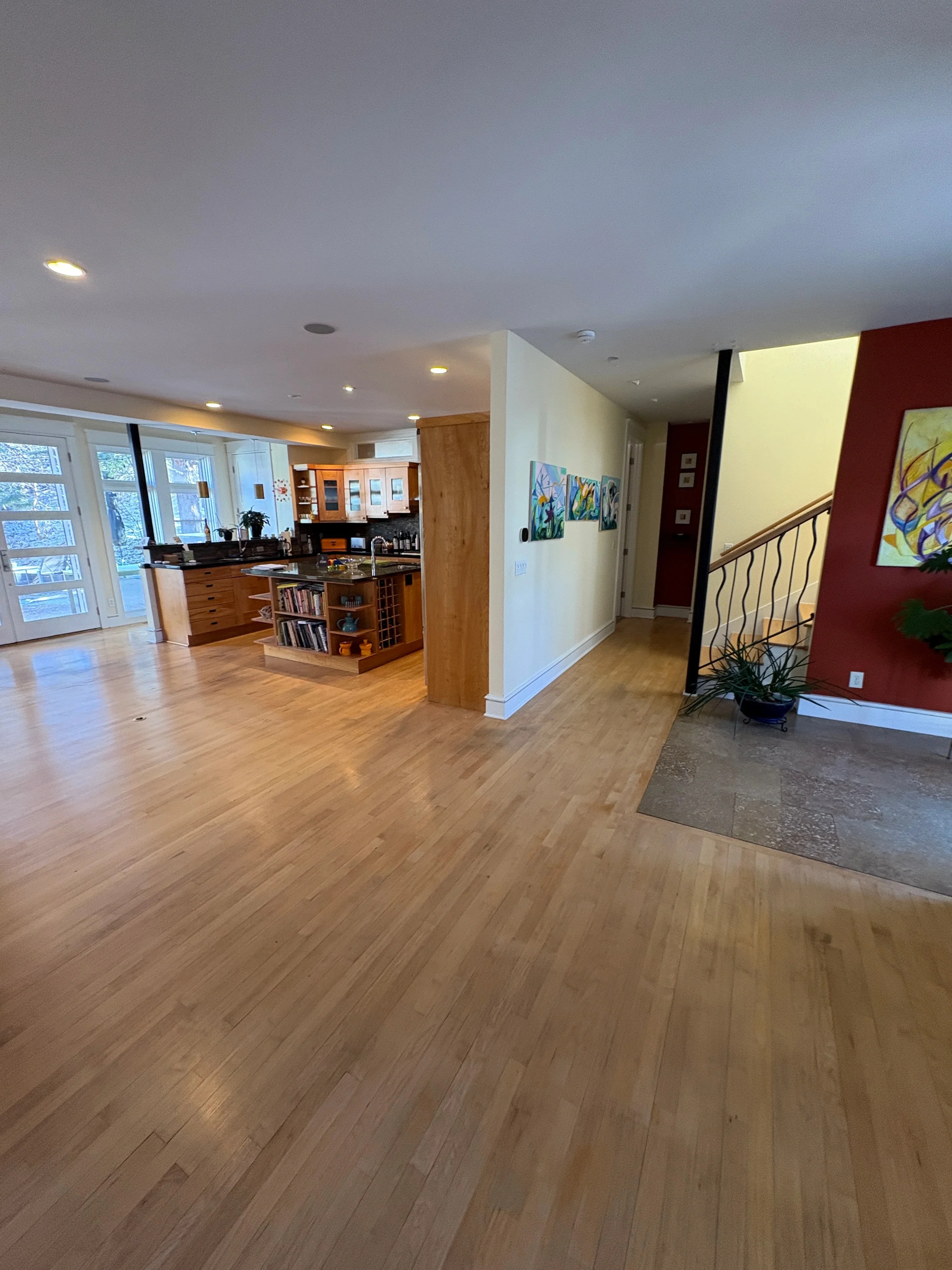 Hardwood flooring installation in open-concept home with kitchen and staircase entry
